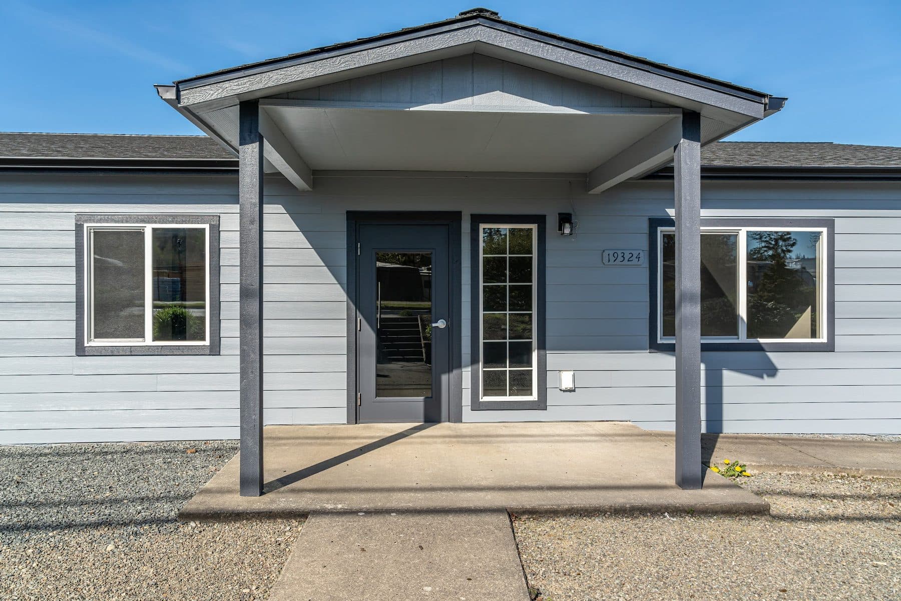 Front entry of the Arlington industrial building at 19324 67th Avenue NE, with a covered porch and gray siding.